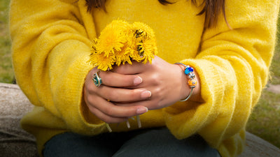 Jonc Trollbeads et modèle tenant des fleurs jaunes