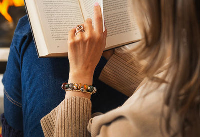 Lire un livre près du feu, portant la collection Trollbeads Automne 2025